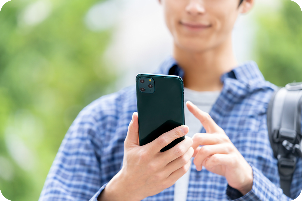 スマートフォンでご予約・お問い合わせをしている男性のイメージ画像